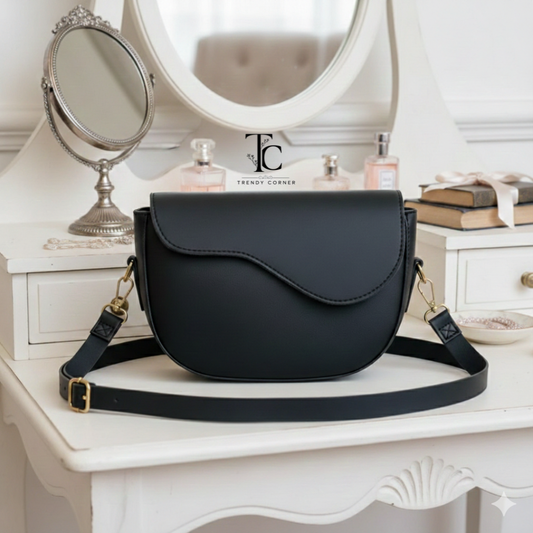 Curved black women's shoulder bag with flap design from Trendyspot.pk, stylish accessory for casual and formal wear.